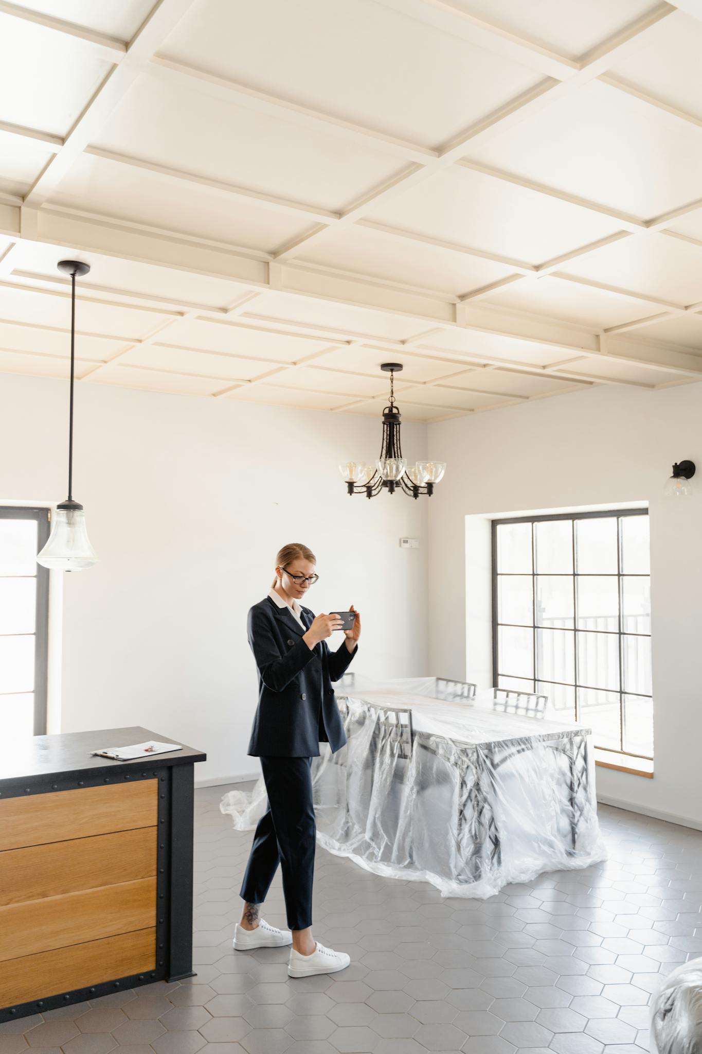 A real estate agent photographs the interior of a modern unfurnished home.